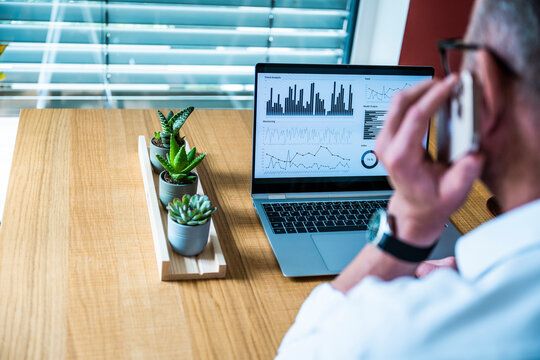 Male broker analyzes financial data on a laptop in the office