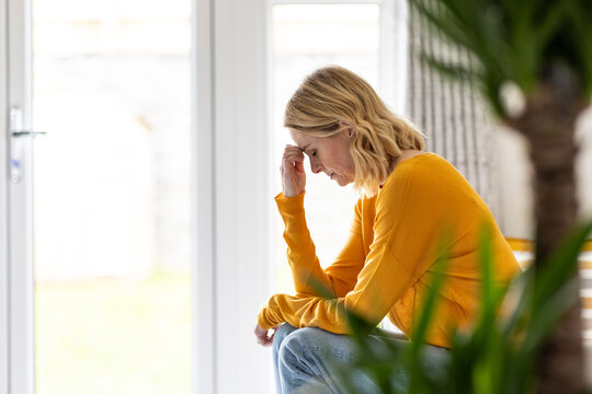 Depressed mature woman sitting at home