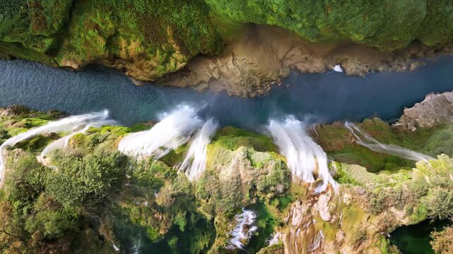 Aerial view of majestic waterfalls flowing down into deep canyon river in Mexico.