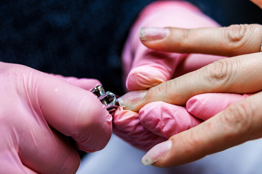 Manicurist trimming customer nails in a beauty salon for professional nail care