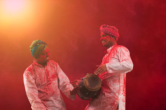 Two Young Indian men With Colored Face Dancing During Holi Color festival