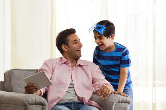 Boy with mask laughing with his father looking at each other