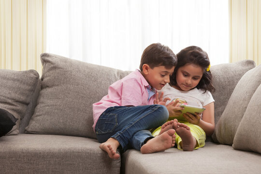 Brother and sister using digital tablet