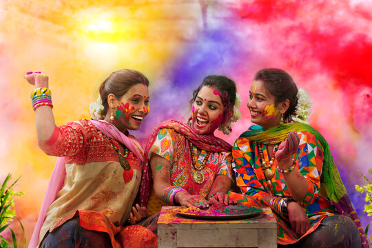 Three teenage Indian girls celebrating Holi festival with traditional dresses and ornaments