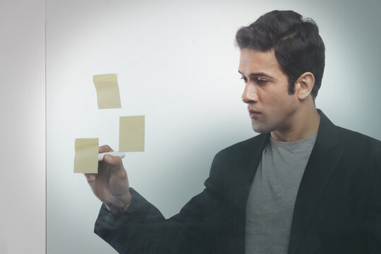 Businessman writing on adhesive notes in office
