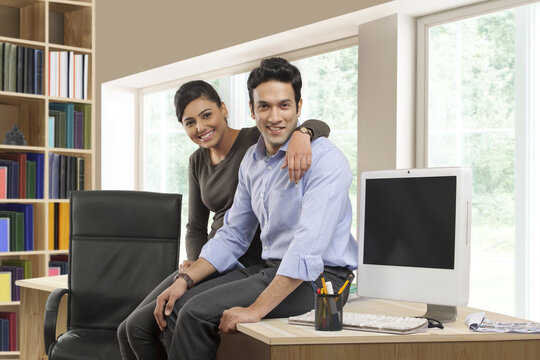 Smiling businessman and businesswoman in office
