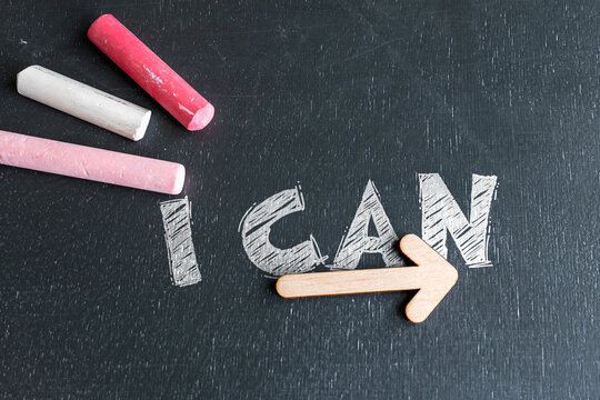 I CAN Motivation Message with Wooden Arrow on Black Chalkboard