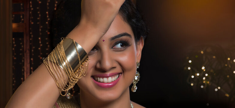 Close-up portrait of  young woman posing with bracelet in hand
