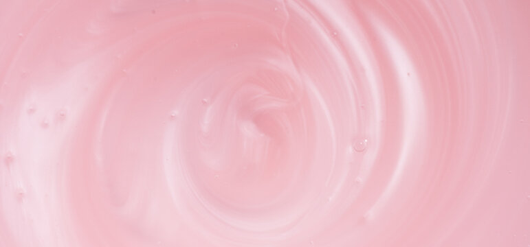 Pearlescent pink liquid soap, shower gel swirl texture, surface of liquid fluid, background, shampoo texture, body care cosmetic, texture of liquid washing gel, soap backdrop top view, from above.