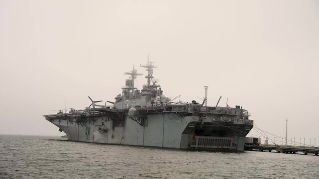 Amphibious Assault Ship Moored At Naval Pier Supporting Maritime Security And Expeditionary Operations Readiness.