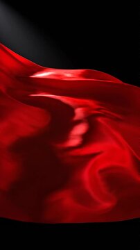 Red silk fabric rippling in slow motion on black