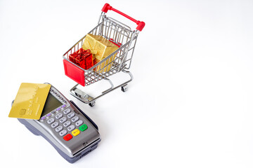 Retail and e-commerce payment — card, POS terminal and mini shopping cart with gift boxes, cashless purchase concept © 9dreamstudio