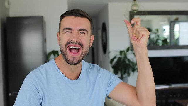 Happy man snapping fingers at camera, signaling something is changing