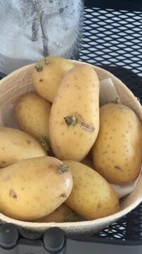 Top-down close-up of sprouting potatoes in a basket