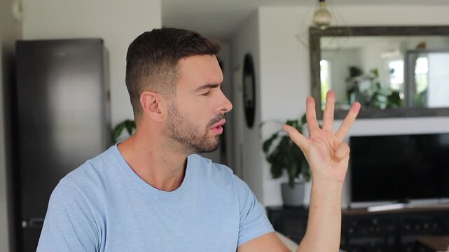 Doubtful looking man counting five fingers toward camera 