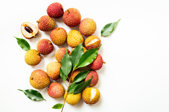 Fresh lychee fruit with green leaves, top view