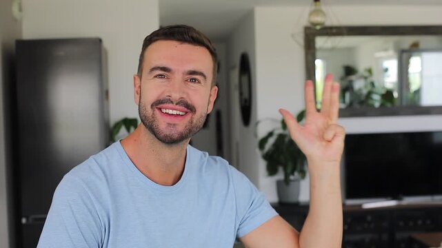 Man counting five fingers toward camera before smiling with joy