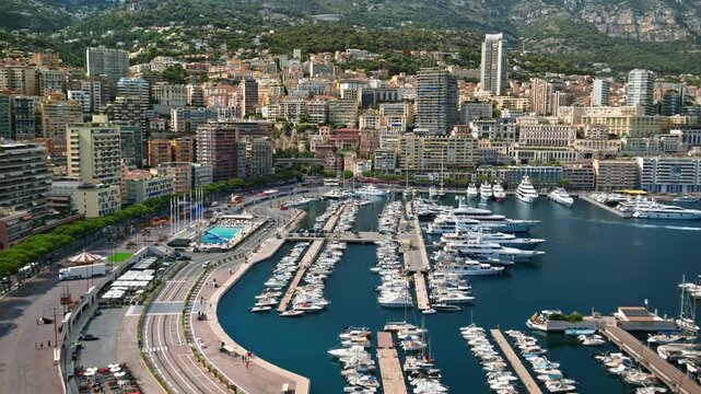 Aerial panoramic view of port hercules marina in monte carlo monaco showing luxury yachts and modern high rise apartment buildings.