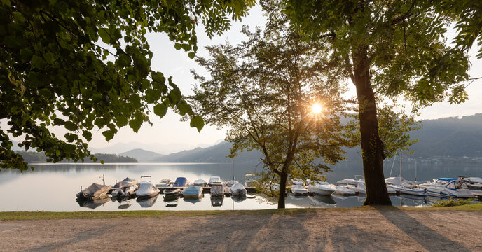 A small harbour with lake boats. A romantic scene in Caslano, Switzerland. Early morning with the sun behind the scene.