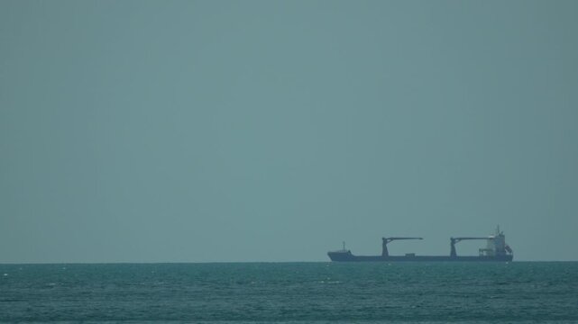Cargo ship, ocean, horizon: Distant freighter sailing peacefully on calm sea