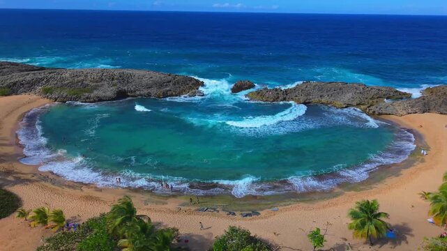 An aerial landscape shot highlights the rugged coral reefs surrounding the popular swimming cove at Mar Chiquita, Puerto Rico.
