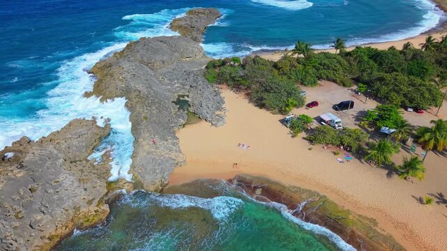 A smooth drone flight offers a bird's-eye view of sunbathers dotting the shore of Mar Chiquita Beach in Puerto Rico.
