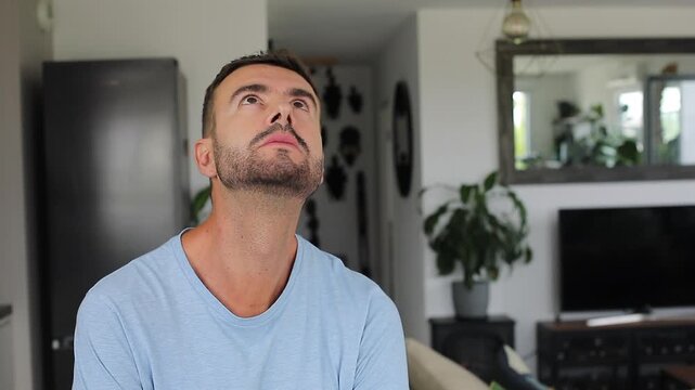 Man looking up with shocked expression at something below frame.