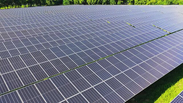 Drone flying forward between long rows of solar panels
