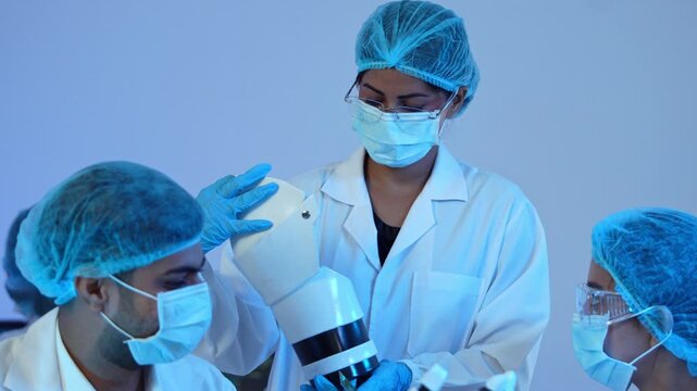 Team of engineer assembling robotic prosthesis part inside biomedical laboratory during innovative medical technology development research project