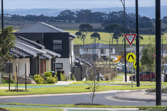 Quiet suburban street corner lined with modern residential homes near mt atkinson in Truganina, an outer suburb of Melbourne, Australia. Open farmland&nbsp;and rolling hills stretch across the background