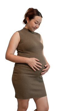 Pregnant woman in a brown knit dress cradling her belly and looking down, isolated on a transparent background.