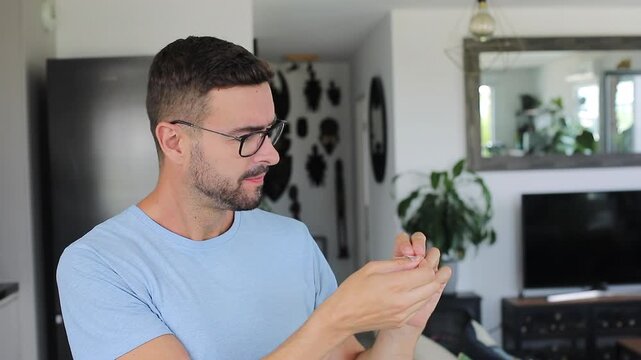 Man carefully cleaning his reading glasses with special wet wipe