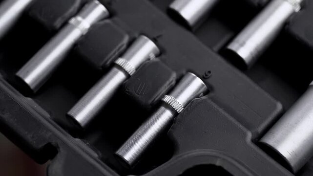 Top view close-up of rotating open toolbox with complete set of socket wrenches, ratchets, and drive bits