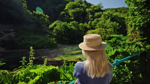 Woman in straw hat at Blue Eye spring in Albania