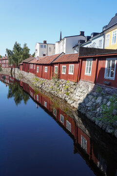Traditional red wooden houses reflected in river water