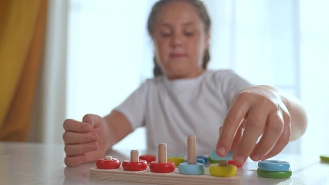 Child playing with puzzle indoors. Young girl solving colorful puzzle pieces. Leisure time activity improving focus and motor skills. Kid enjoying puzzle assembly. Educational leisure for child home.