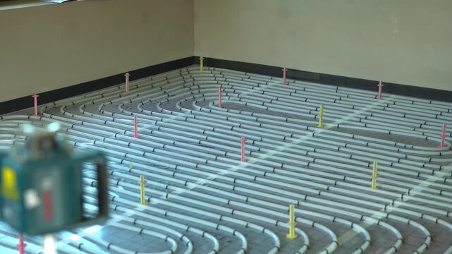 Laser leveling tool working on underfloor heating system installation