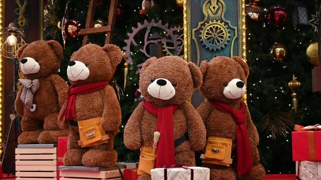Four adorable mechanical teddy bears moving in festive christmas holiday display.