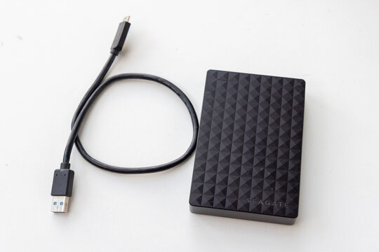 External portable hard drive with connection cable on surface