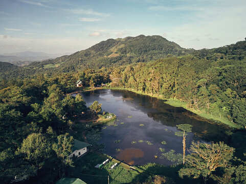 Aerial view of Selva Negra lake surrounded by dense tropical forest and rolling mountains in Selva Negra, Matagalpa, Nicaragua.