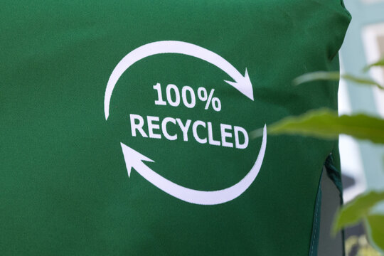 100% Recycled Sign on Green Textured Background Representing Sustainability and Eco-Friendly Concept.