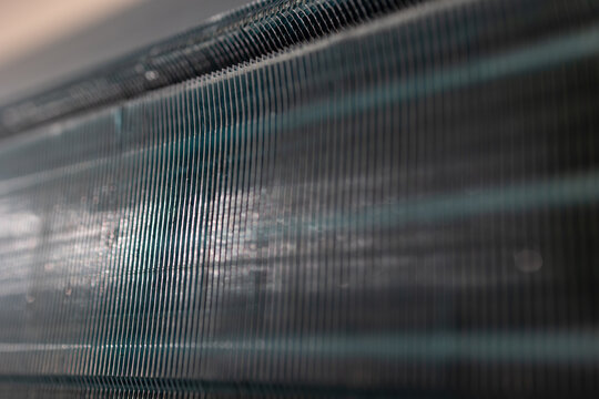 Air conditioner cooling fins detail. HVAC heat exchanger coils. Macro view, soft light, indoor system