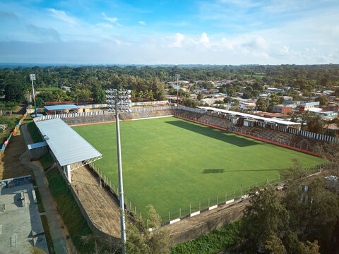 Aerial view of Estadio Cacique Diriangen with its green pitch, stadium seating, and floodlight towers, surrounded by the town of Diriamba, Carazo, Nicaragua.