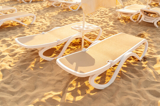 beach lounge chairs stationary on sandy beach with relaxed and serene atmosphere top-down view webb.