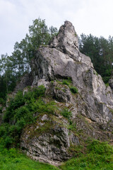 Monumental Zabi Kon limestone formation topped by a metal cross in Kobylanska Valley near Krakow, Poland. The vertical Jurassic crag rises above birch and pine woodland, creating a recognizable Polish © Volha