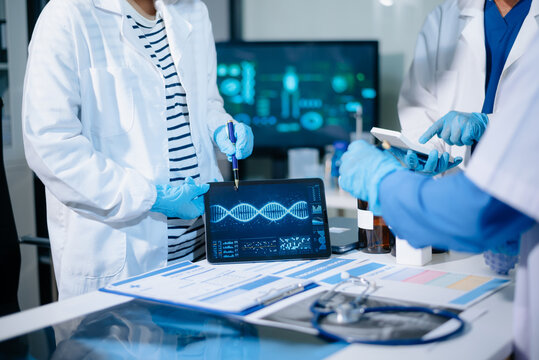 Scientists analyze DNA genetics data using digital technology in a modern medical laboratory, advancing biotechnology, genomics, healthcare research, and precision medicine.
