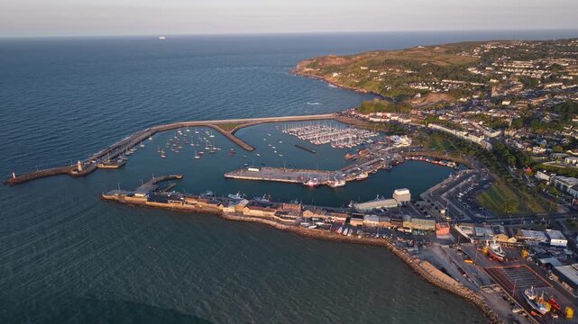 Amazing aerial panorama of Howth Harbour and seaside homes at sunset, Ireland
