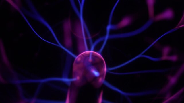 Close-up of a plasma ball coil. The plasma ball creates purple energy beams.