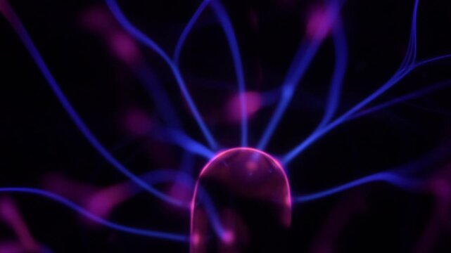 Close-up of a plasma ball coil. The plasma ball creates purple energy beams.