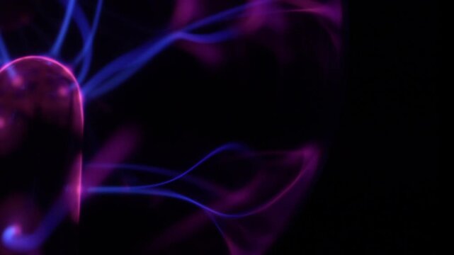 Close-up of the discharge rays of a plasma ball in shades of purple.
